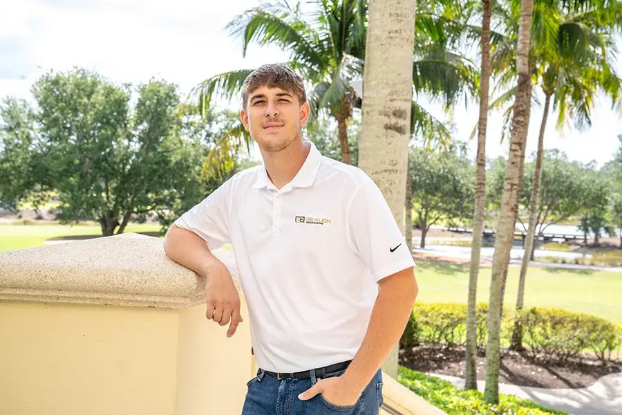 President and installation specialist David Butar standing outside a country club surrounded by palm trees.
